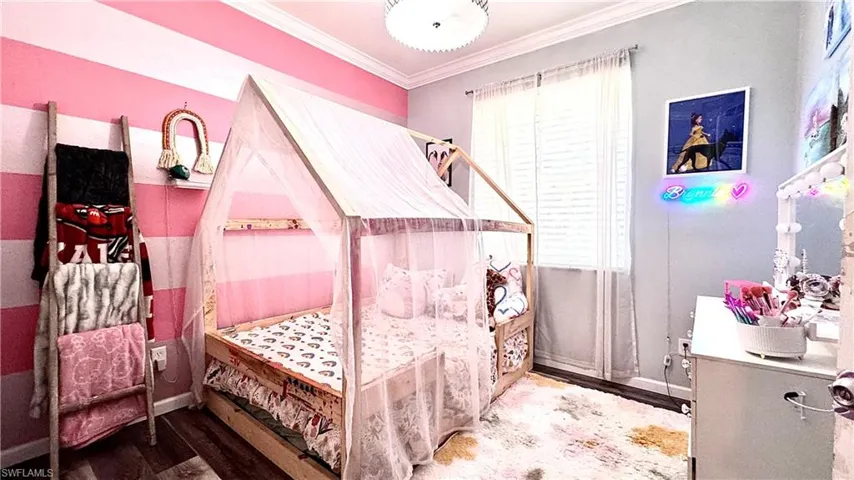 Bedroom featuring ornamental molding and wood finished floors