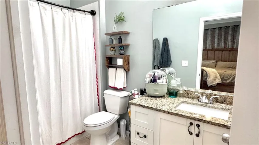Bathroom featuring vanity, curtained shower, ensuite bath, and light tile patterned flooring