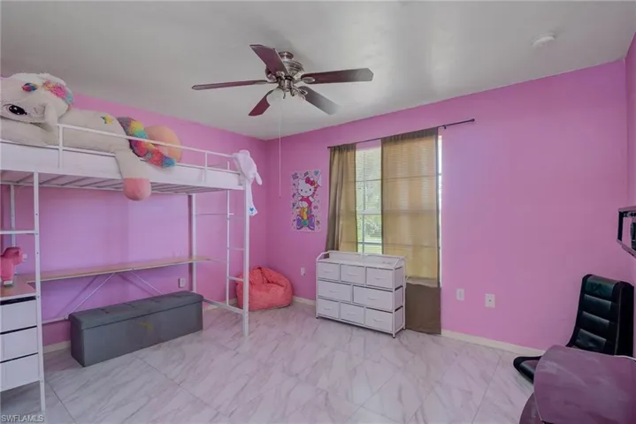 Bedroom with marble finish floor, ceiling fan, and baseboards