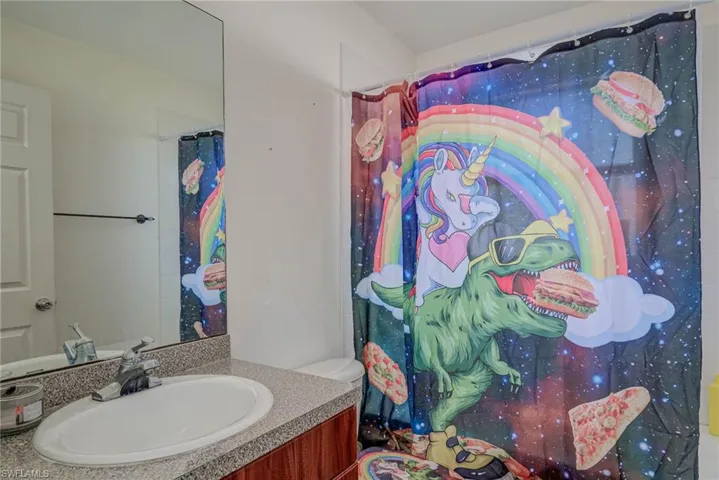 Bathroom featuring a shower with shower curtain and vanity