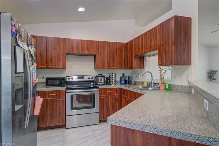 Kitchen with a sink, light countertops, recessed lighting, stainless steel appliances, and marble finish floor