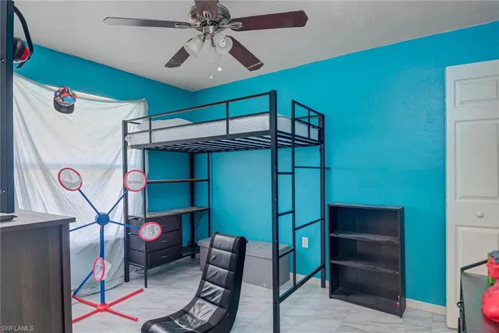 Bedroom with marble finish floor and ceiling fan