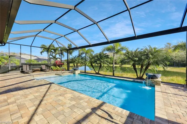 Outdoor pool with a patio and glass enclosure