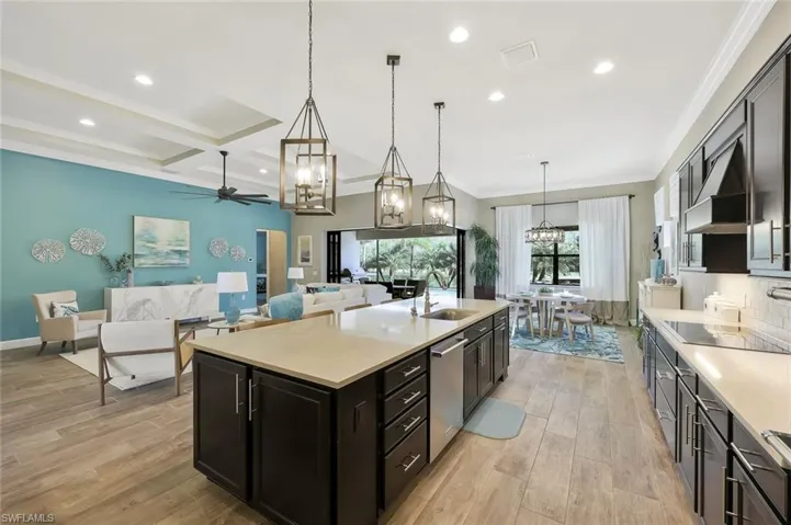 Kitchen featuring black electric stovetop, a sink, light countertops, light wood-type flooring, and dishwasher