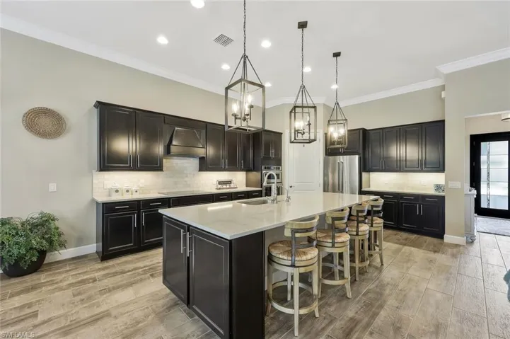 Kitchen featuring stainless steel appliances, a sink, visible vents, light wood-type flooring, and custom range hood