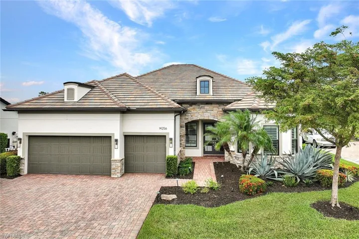 French provincial home featuring decorative driveway, a garage, stone siding, and stucco siding