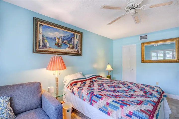 Bedroom featuring a textured ceiling, visible vents, a ceiling fan, and baseboards