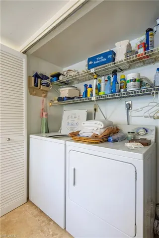 Laundry area featuring light tile patterned floors, independent washer and dryer, and laundry area