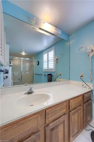 Bathroom with tile patterned floors, vanity, and a shower stall