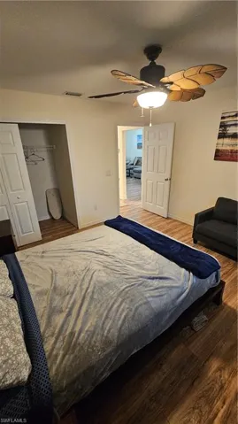 Wood-finish flooring, ceiling fan with light fixture, and bi-fold closet doors