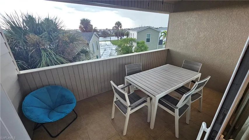 Outdoor balcony with a panel-sided privacy wall and tiled flooring