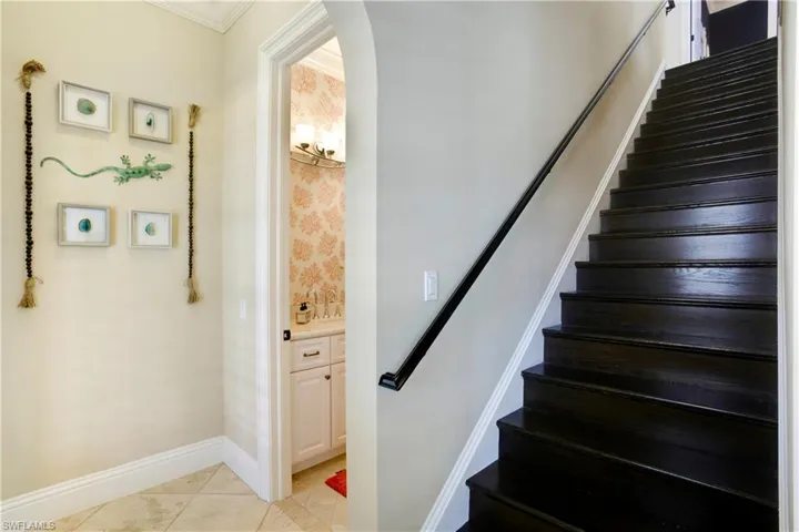 Wood Staircase to 2nd level showing full bath to left