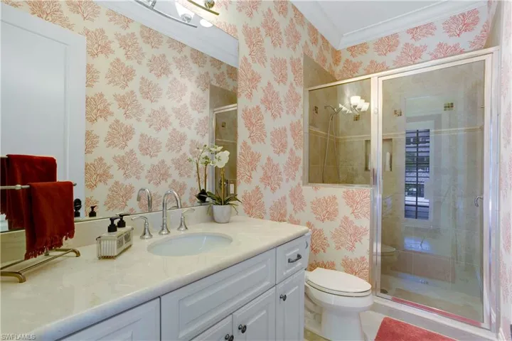 Full pool bath with vanity, crown molding, a stall shower, and wallpapered walls