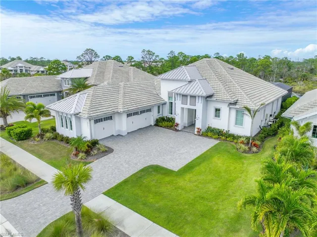 View of front of home with a garage, decorative driveway, a front yard, and stucco siding