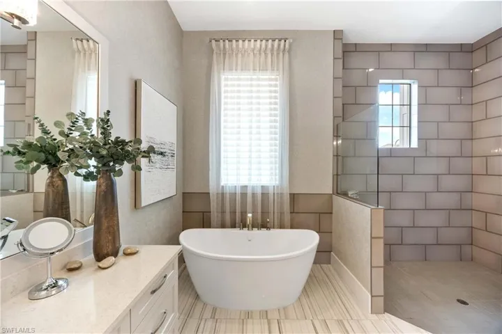 Full bath with a soaking tub, a walk in shower, vanity, tile walls, and tile patterned floors