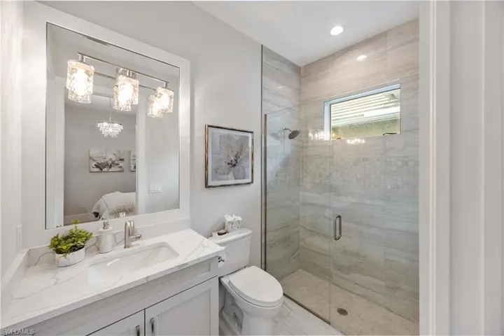 Full bathroom with a shower stall, vanity, ensuite bathroom, and recessed lighting