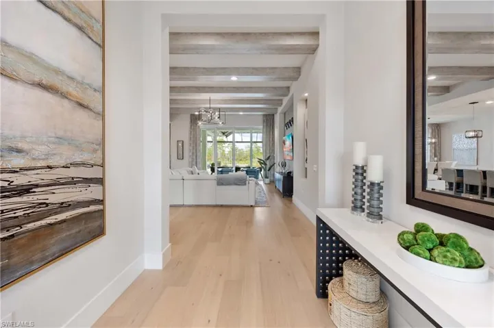 Corridor featuring beam ceiling, a chandelier, light wood-style floors, and recessed lighting