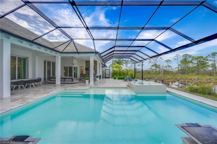 View of swimming pool with a sunroom, a ceiling fan, a patio, and a lanai