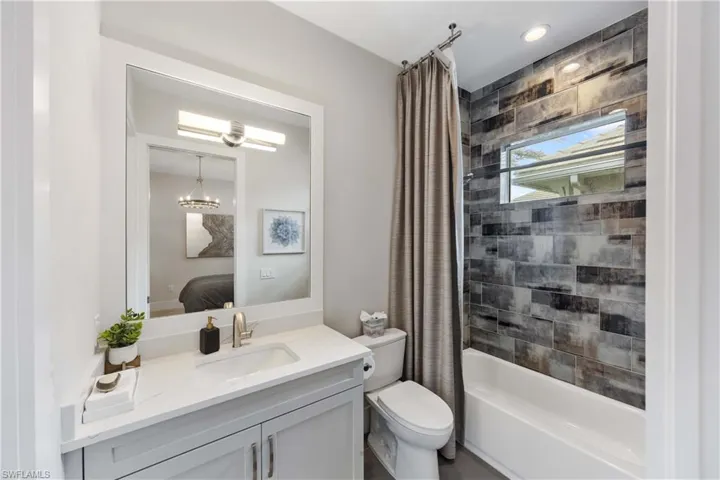 Ensuite bathroom with shower / tub combo and vanity