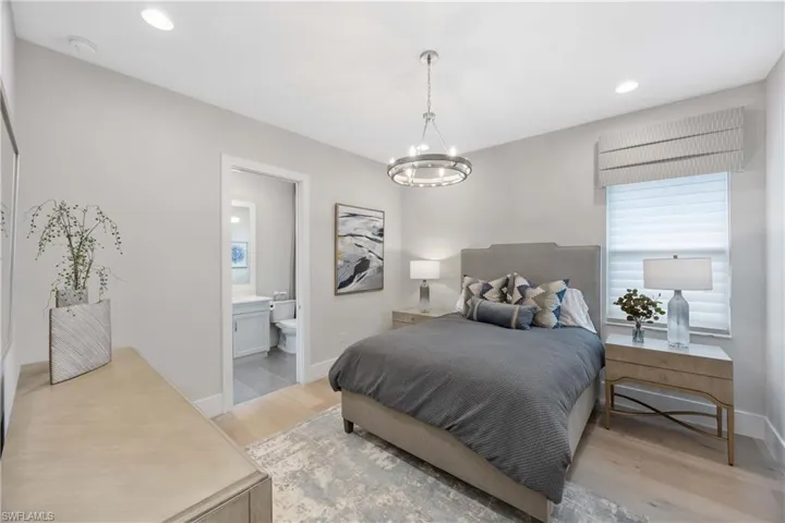 Bedroom featuring light wood-style floors, recessed lighting, a chandelier, and ensuite bathroom