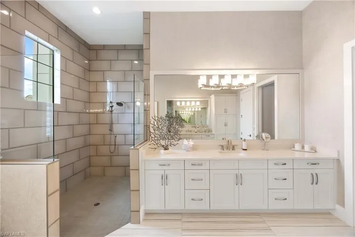 Full bath featuring vanity, a walk in shower, and recessed lighting