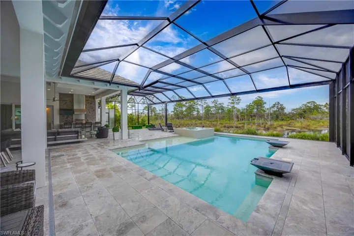 View of swimming pool with a patio, a sunroom, glass enclosure, a ceiling fan, and a pool with connected hot tub