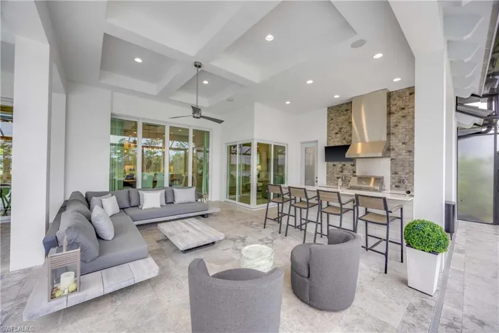 Living room with coffered ceiling, beamed ceiling, a towering ceiling, recessed lighting, and ceiling fan