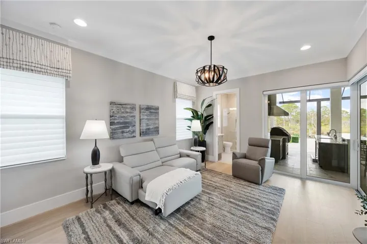 Living area with light wood-style flooring, recessed lighting, and a chandelier