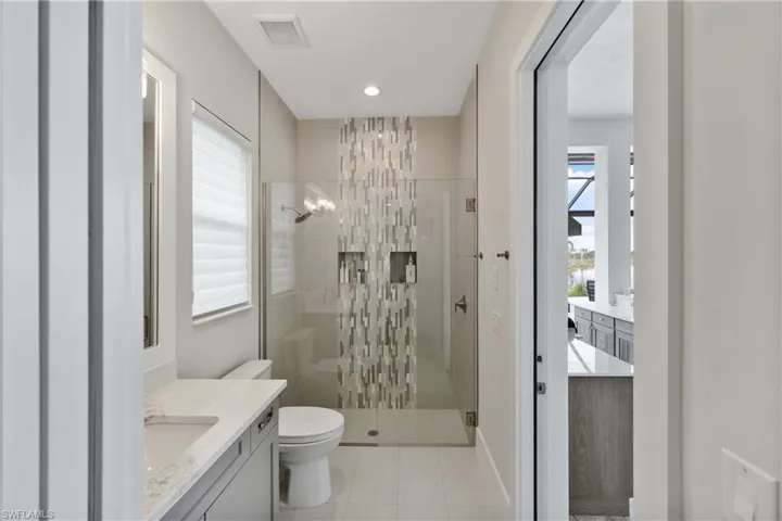 Full bathroom with a shower stall, vanity, light tile patterned floors, plenty of natural light, and recessed lighting
