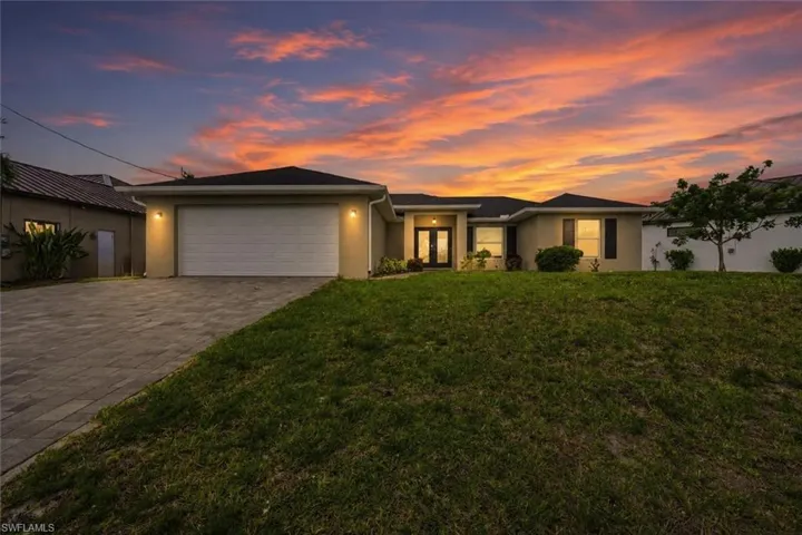 Exterior residence with an attached garage and a paver driveway