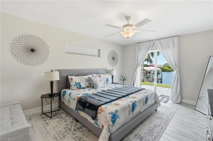 Bedroom featuring white plank-style flooring and a ceiling fan with integrated lighting