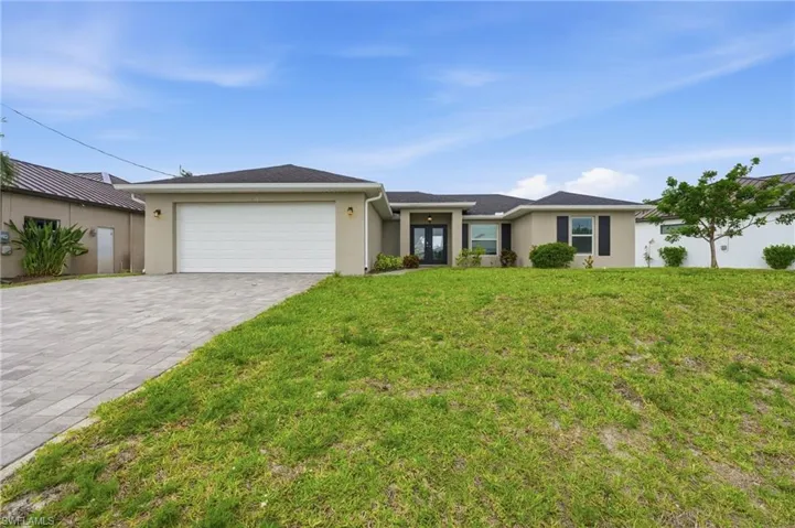 Exterior residence with an attached garage and a paver driveway