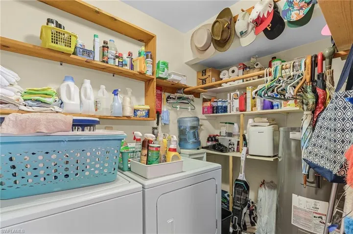 Laundry room with electric water heater and washer and clothes dryer