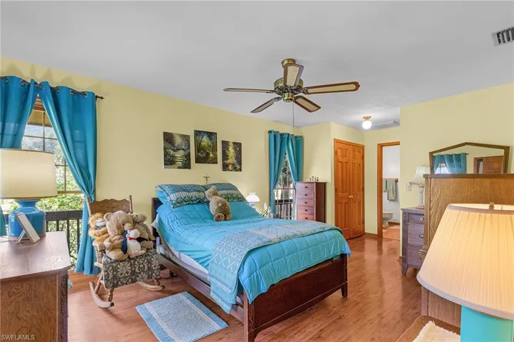 Bedroom with wood finished floors, ceiling fan, a closet, and ensuite bathroom