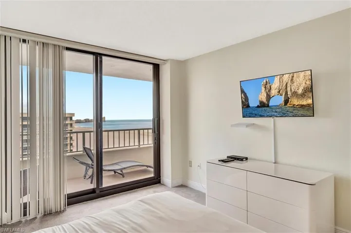 Unfurnished bedroom featuring light carpet, access to outside, and floor to ceiling windows