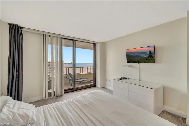 Carpeted bedroom with access to exterior and a wall of windows