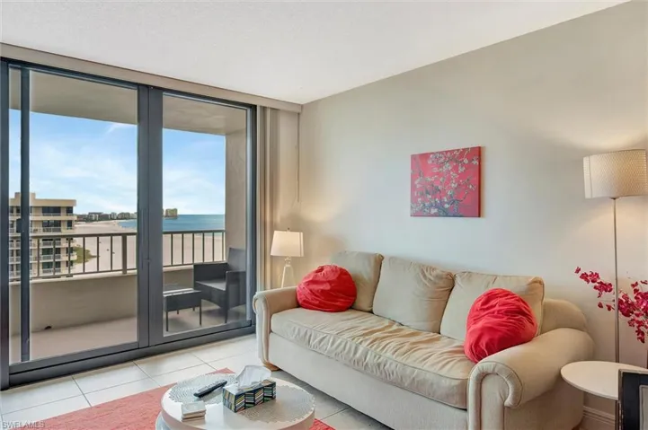 Living area featuring a water view, tile patterned floors, and floor to ceiling windows