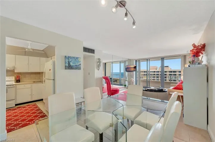 Dining area with light tile patterned floors, floor to ceiling windows, and ceiling fan