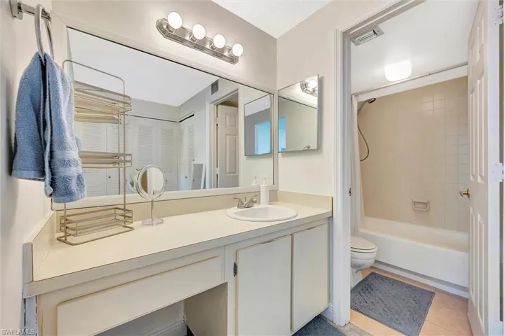 Bathroom featuring vanity, shower / bath combination with curtain, and light tile patterned flooring