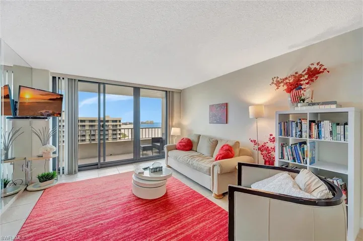 Living area featuring a textured ceiling, a wall of windows, and tile patterned flooring