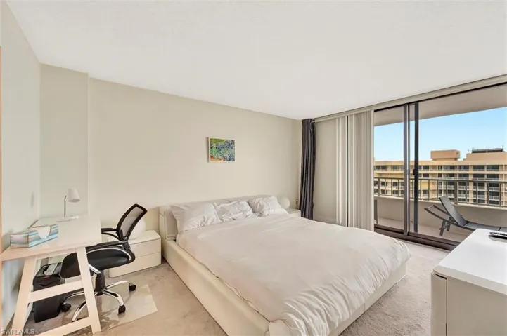 Bedroom featuring a desk, light colored carpet, access to outside, and floor to ceiling windows