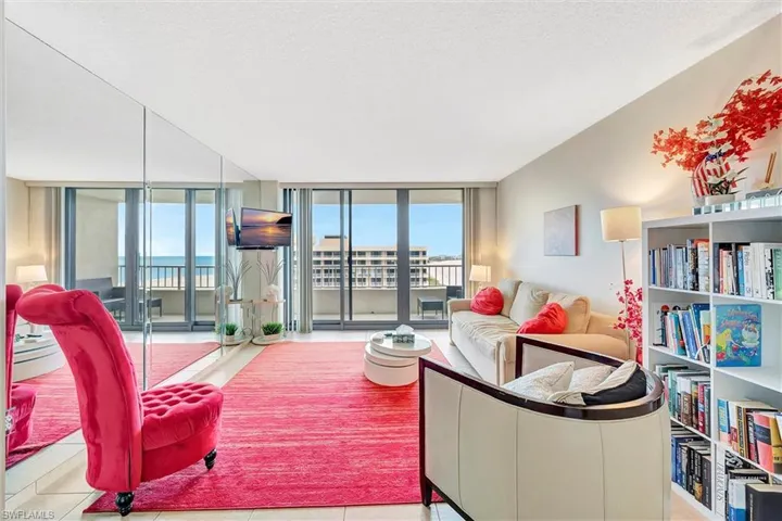 Living room with expansive windows, tile patterned floors, and a textured ceiling