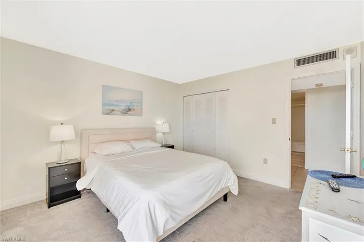 Bedroom with light carpet and a closet