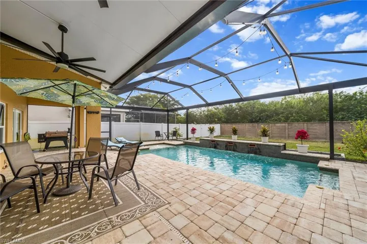 View of swimming pool featuring a lanai, a sunroom, a patio, and a fenced backyard