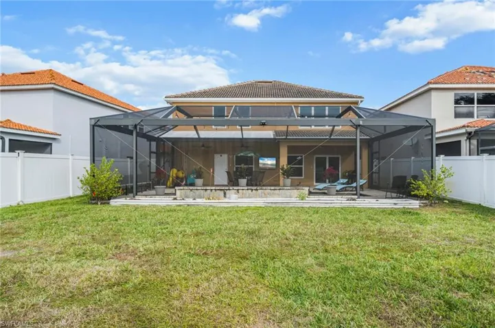 Back of house featuring a fenced backyard, a lanai, and a sunroom