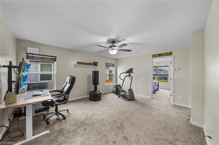 Office space with carpet and a ceiling fan