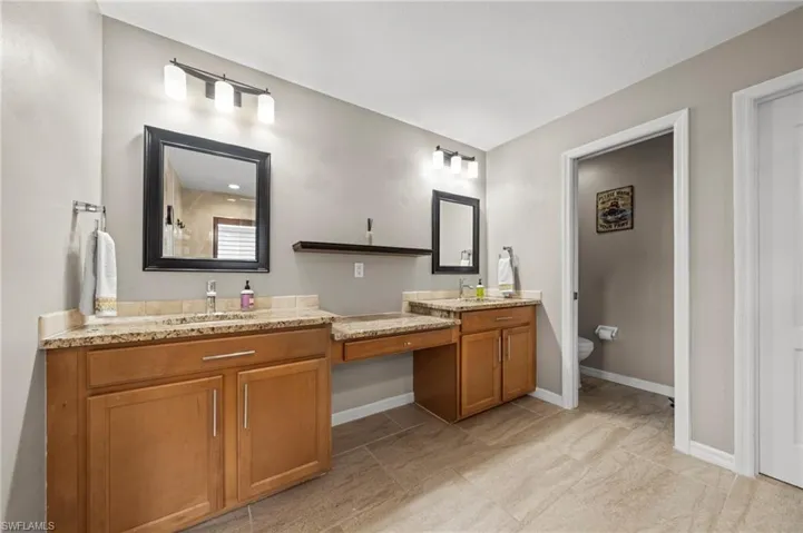 Bathroom featuring double vanity and toilet