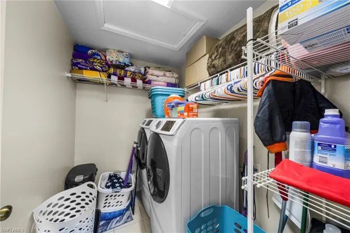 Laundry room with washer and dryer and tile patterned floors