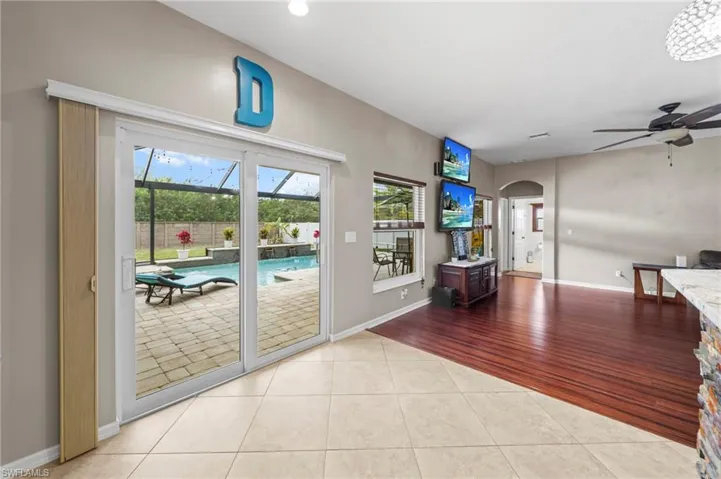 Entryway with ceiling fan, arched walkways, wood finished floors, and a sunroom