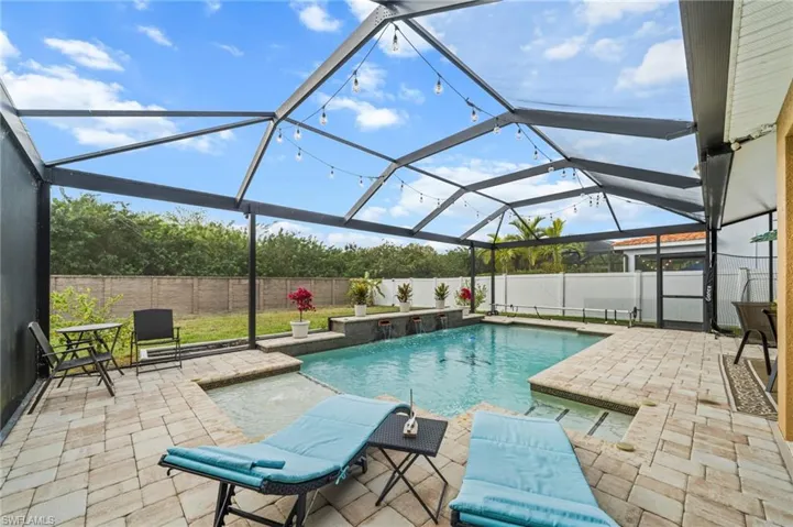View of pool featuring glass enclosure, a sunroom, a patio area, and a fenced backyard